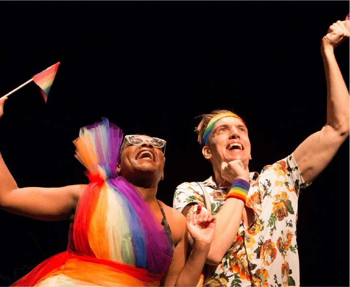 Close up of two people performing on a joyous scene on stage