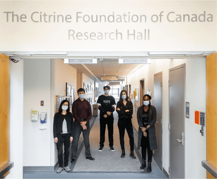 Diverse group standing in front of "The Citrine Foundation of Canada Research Hall"